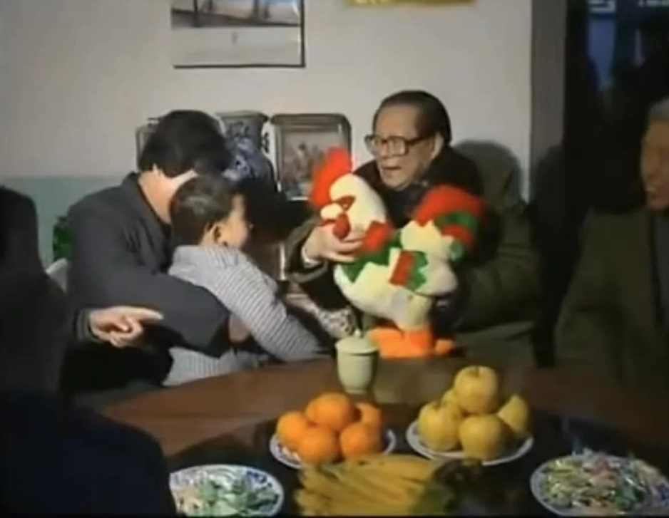 1993年除夕，江泽民到北京房山农民家中拜年，并送给农民小孩一直公鸡玩偶。网上图片