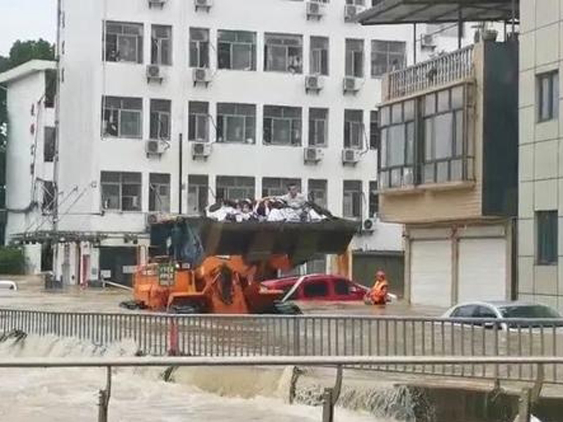 576名參加今年高考的學生被困校內，救援人員就組織了大型的鏟車，輪流進入校園轉運考生。(網圖)