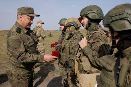 俄防長紹伊古(左)上周到南部軍區一處訓練場向軍人頒獎。路透社