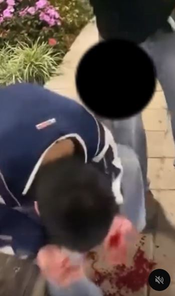 青年被旁邊男子以手推頭。網片截圖