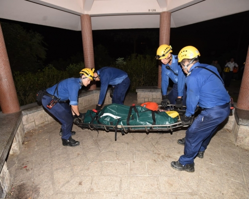 消防員將死者遺體移至公園的涼亭。