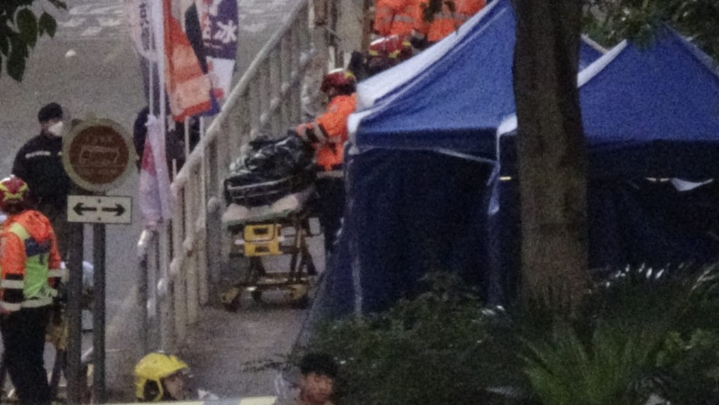 仵工清晨從受災單位抬出五具遺體,其中兩具體形明顯較小。蔡楚輝攝 仵工清晨從受災單位抬出五具遺體,其中兩具體形明顯較小。蔡楚輝攝