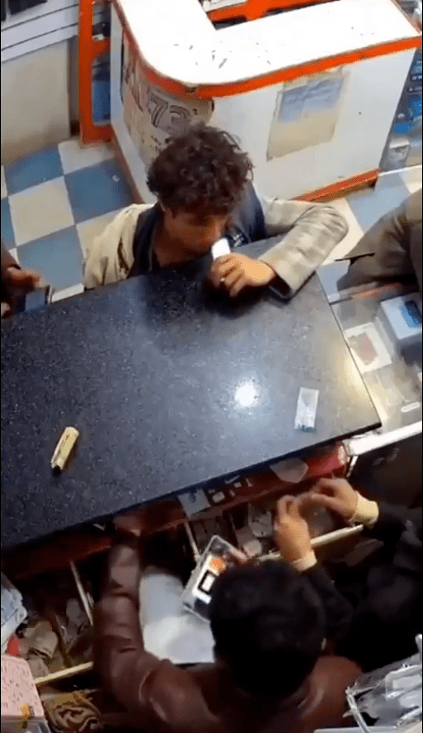 片中顯示一名男童在手機店內，將一枚鋰電池放入口中咀嚼。X@mdredpillawake (下同)