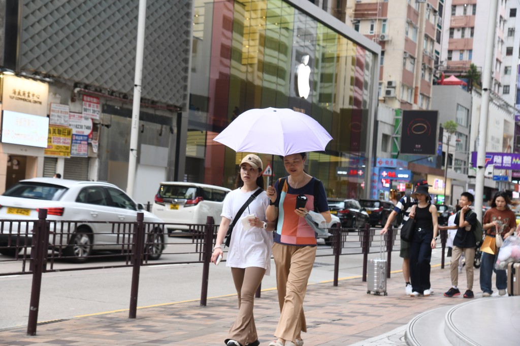 一号风球期间，局部地区下起骤雨，巿民也要撑伞。何健勇摄