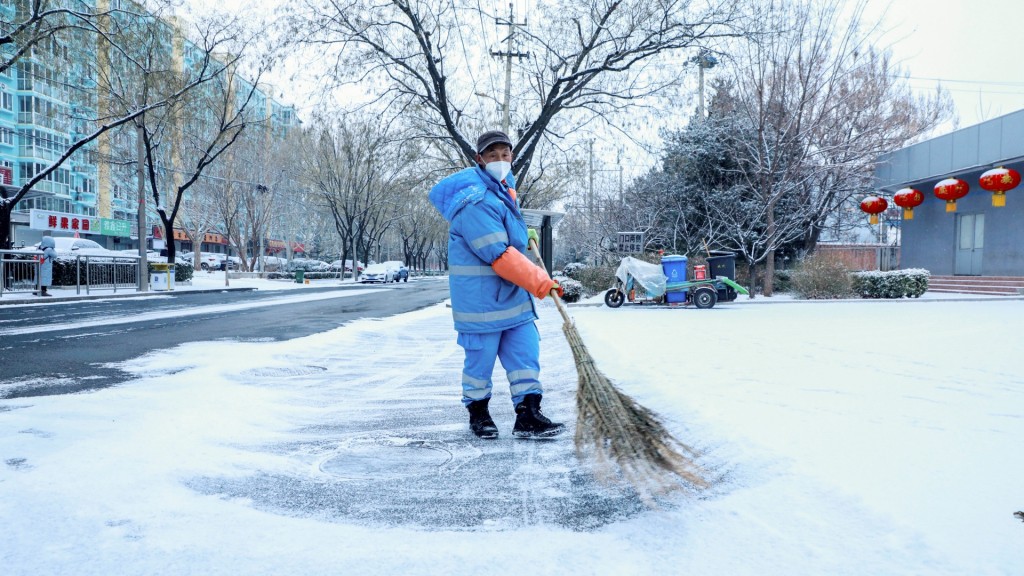 北京市內工人忙於掃雪鏟冰。新華社 
