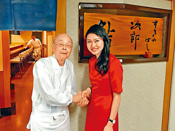 「壽司之神」小野二郎在數寄屋橋次郎本店門外，與外國客人握手合照。