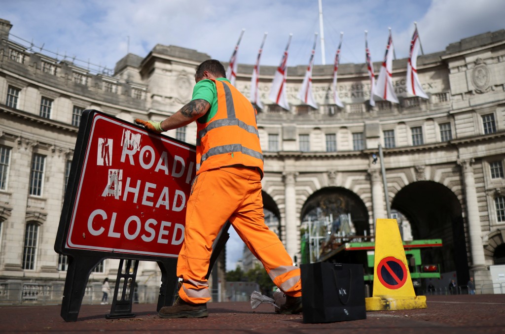 英女皇國葬後，工人在清理路標。路透