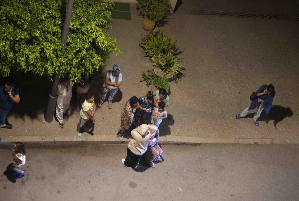 摩洛哥拉巴特发生地震后，人们避难并用手机查看新闻。AP