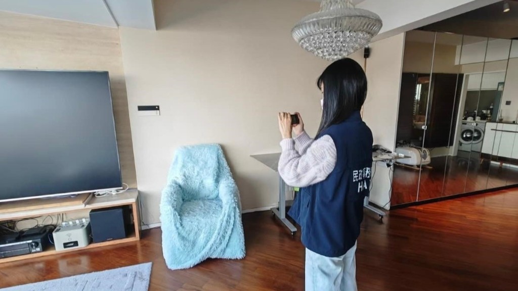 牌照處執法人員在一間懷疑無牌經營的賓館搜集證據。政府新聞處