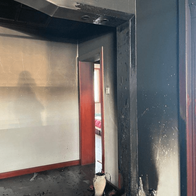 張女士發布照片可見家中木質框已被燒黑，同時黑煙已經將部分天花板燻黑。
