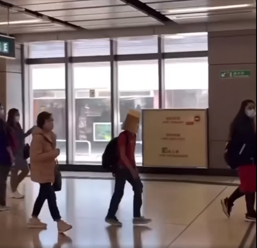 网民直击一名头笠纸袋的红衣乘客入闸后上电梯实况。网上截图