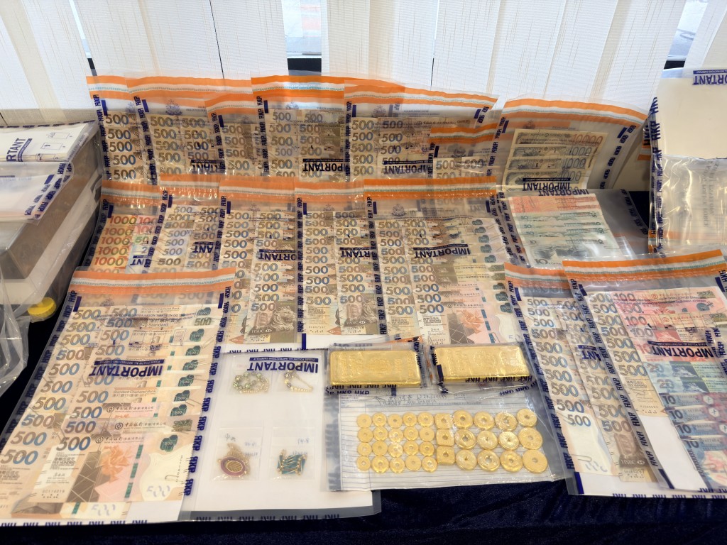警方早前檢獲的一批證物，包括大批金粒及現金。資料圖片