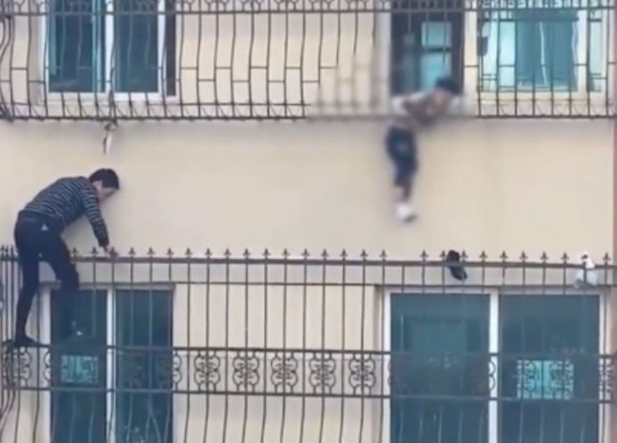 男子爬上四樓救被困男童，腳踏窗外諼欄，非常驚險。