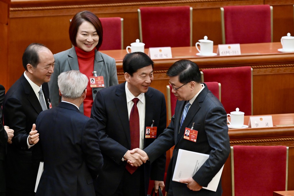 李慧琼亦有上前加入，三人聊天暢談、面露笑容，又不時握手。