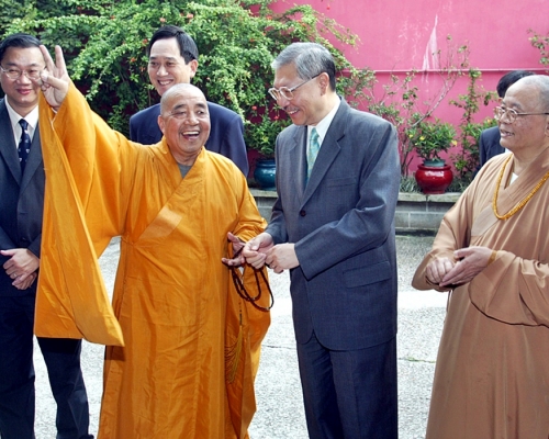 釋智慧要封山,時任房屋及規劃地政局局長孫公孫明揚到寶蓮寺會面,釋智慧之後擺出勝利手勢。資料圖片