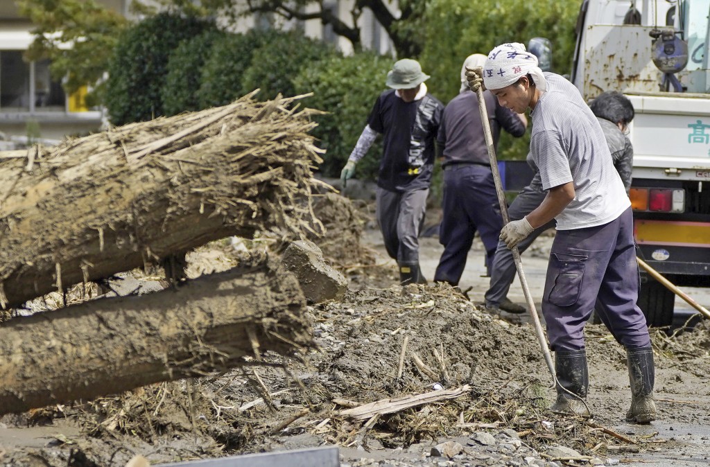 日本南部福岡縣久留米市，民眾在傾盆大雨後清理廢墟。AP