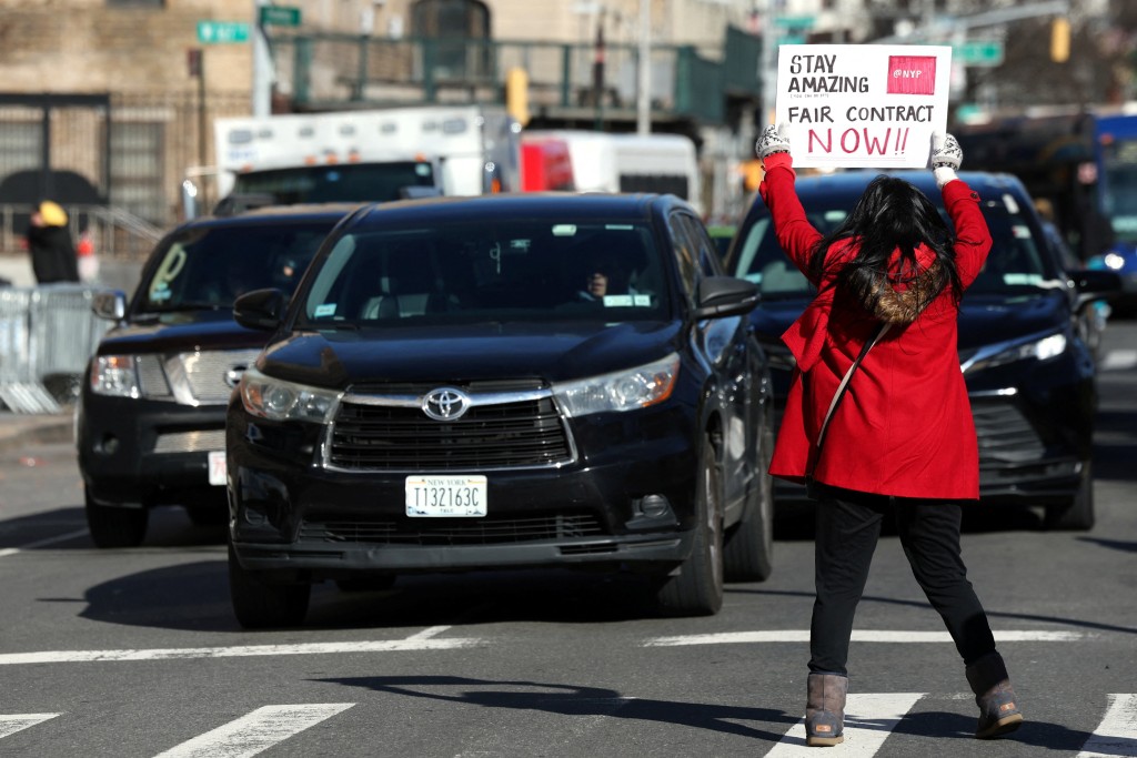罷工護士在馬路中央舉牌抗議。路透社
