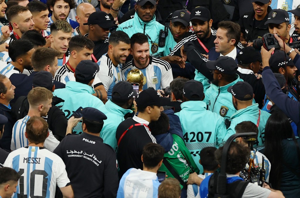 美斯和好友阿古路舉起世界盃獎盃合照。Reuters
