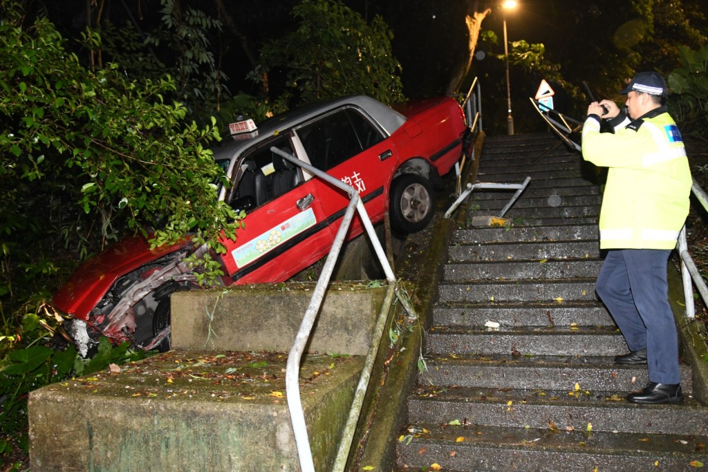 部分車身擱在樓梯的欄杆上及斜坡的石壆上。李家傑攝