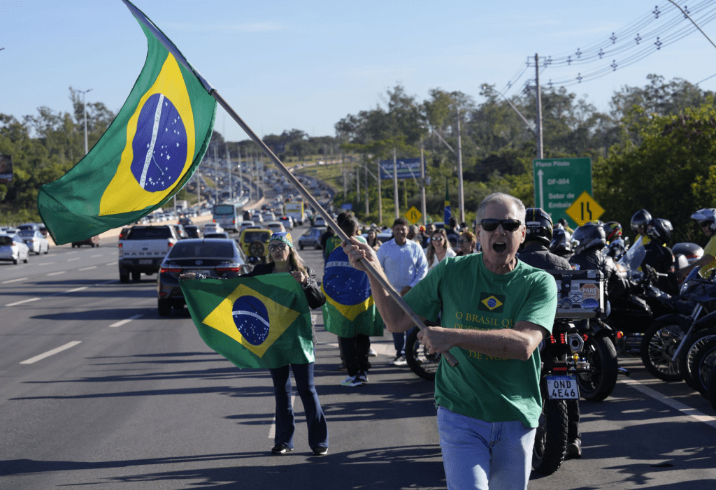 巴西前總統博索納羅（Jair Bolsonaro）返回巴西，大批支持者在機場揮國旗唱國歌迎接。 美聯社