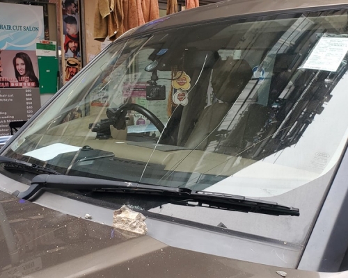 私家車車頭玻璃被石屎擊中現裂痕。林思明攝