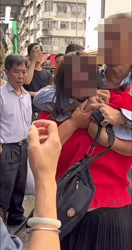 紅衫女子被一名男子從後箍頸及捉手。網上片段截圖