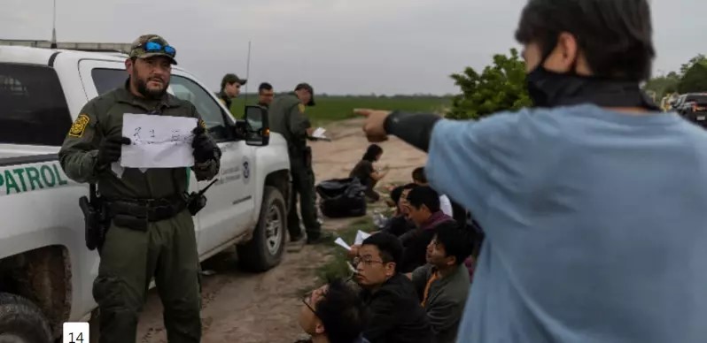 一名美国边境警察向截获的「中国人」展示「民主自由」中文字。