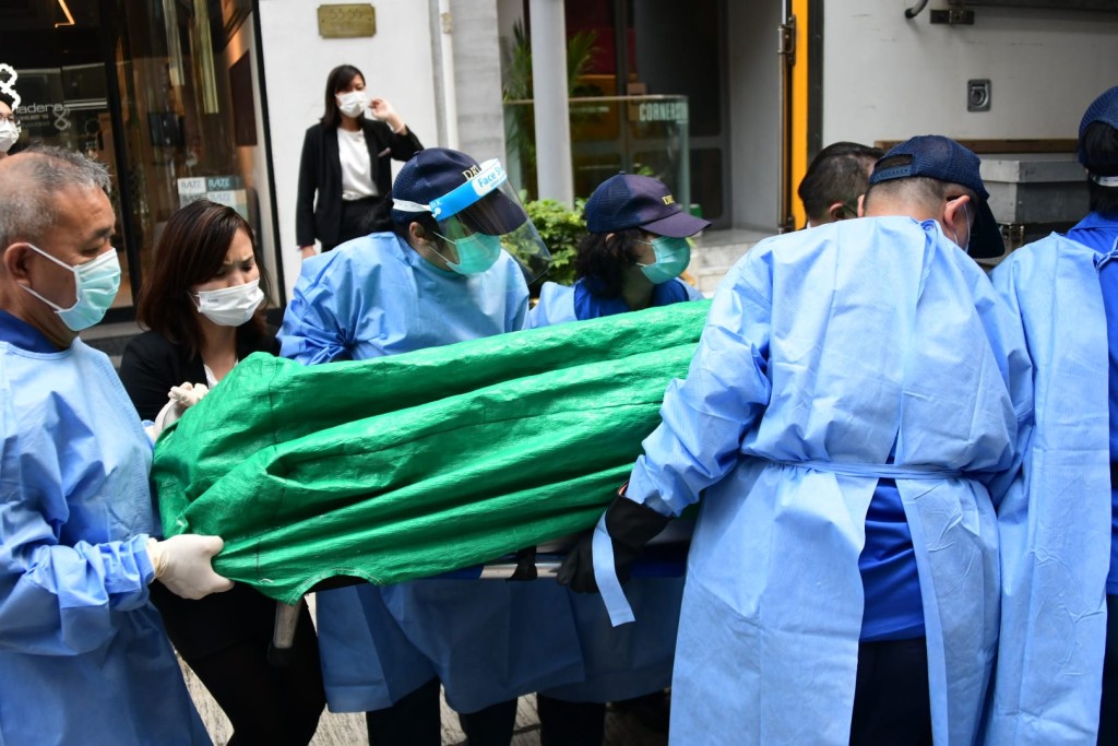 酒店職員幫忙將死者遺體移上黑箱車。