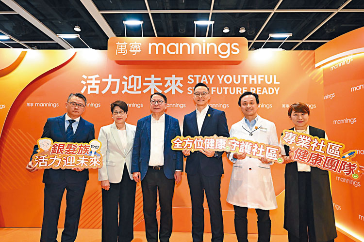 政務司司長陳國基（左三）、香港貿發局副總裁張淑芬（左二）、香港零售管理協會執行總監羅振邦（左一）參觀「美與健生活博覽」萬寧的展覽攤位，與萬寧香港、澳門及中國常務董事劉家昌（右三）、萬寧總藥劑師趙國亮（右二）及萬寧北亞區市場總監鄭虹合照（右一）。