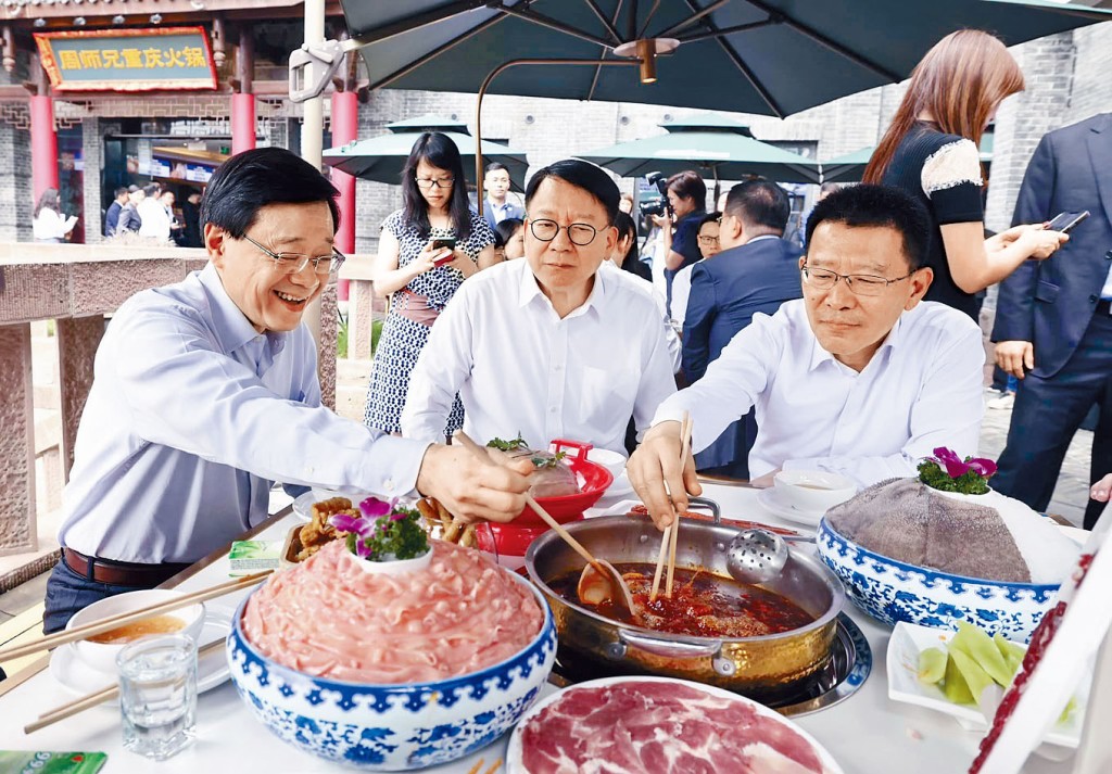 李家超（左）與代表團一行人在磁器口一家火鍋店，品嘗重慶麻辣火鍋。