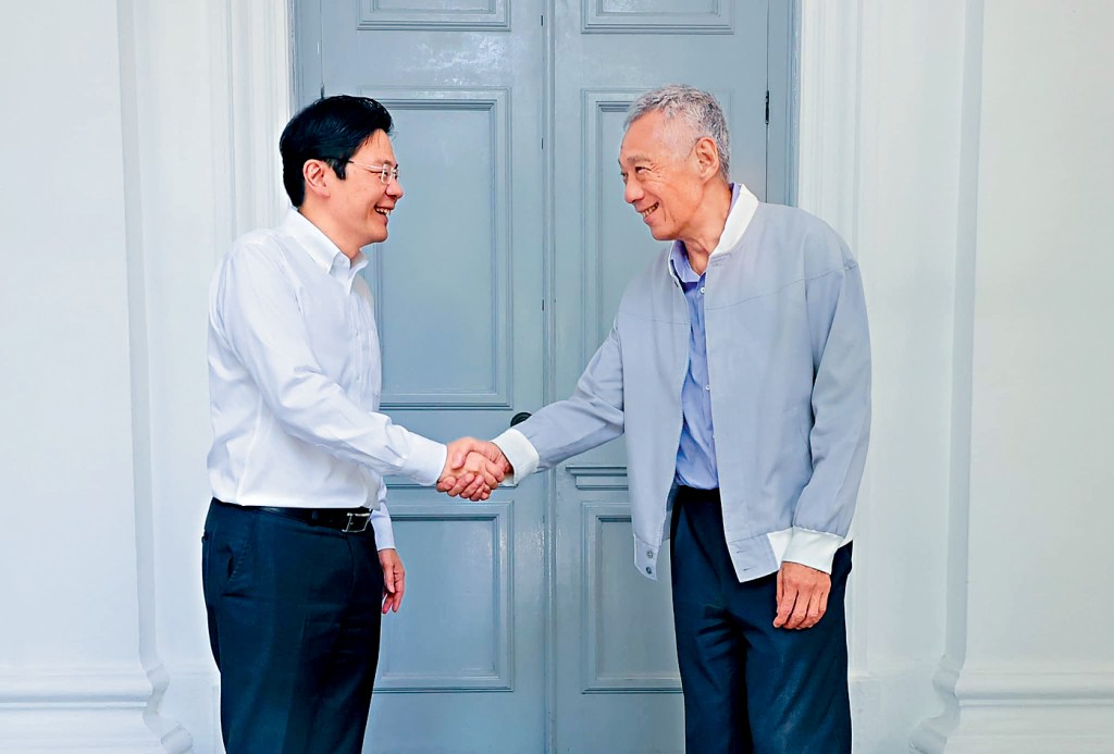 李顯龍上周四主持總理任內最後一次內閣會議,與繼任人黃循財握手。