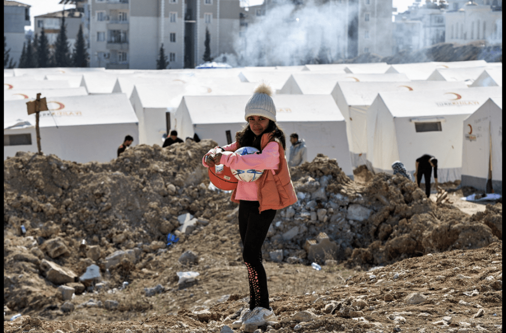 一名女童站在阿德亚曼难民营前。 路透社