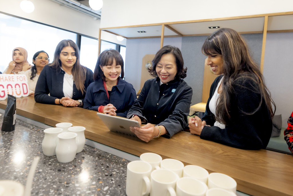 参加者学习以 AI 冲制咖啡 ，了解科技融合咖啡的潮流，她们为民政及青年事务局局长麦美娟 （右二）冲制「心情咖啡」。