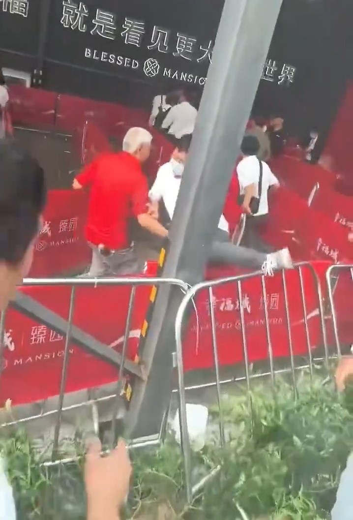 楼盘营销中心外,保安向人群喷辣椒水。微博@金融八卦女 楼盘营销中心外,保安向人群喷辣椒水。微博@金融八卦女