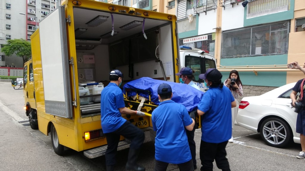 女死者屍體由仵工移離現場。