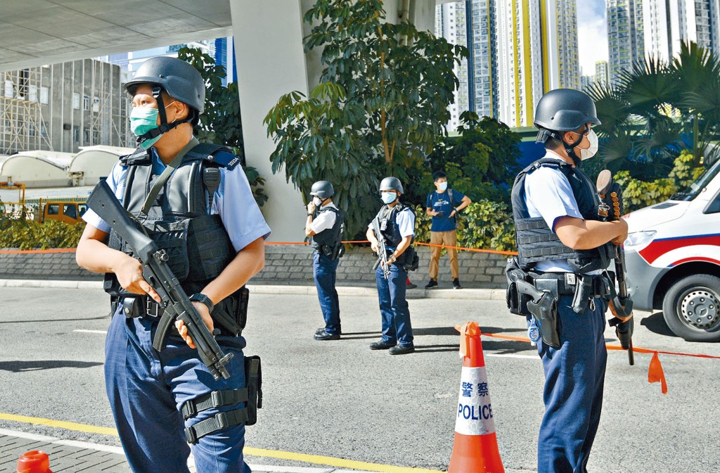 大批全副武装警员，手持长枪在法院外严密戒备。