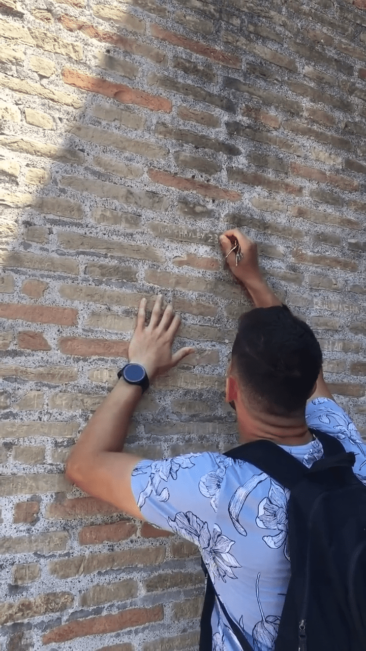 网上流传影片显示，一名男子在罗马斗兽场石墙刻字。