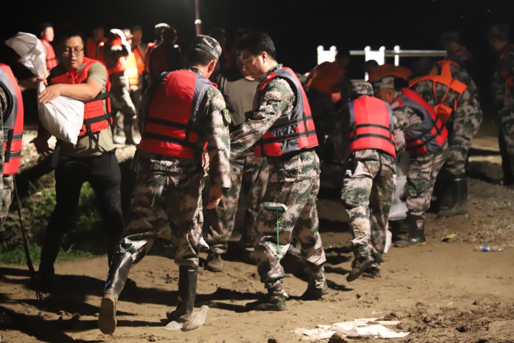 吉林雙遼市人武部組織民兵應急分隊在茂林鎮日新村小清河河段搬運沙袋。新華社