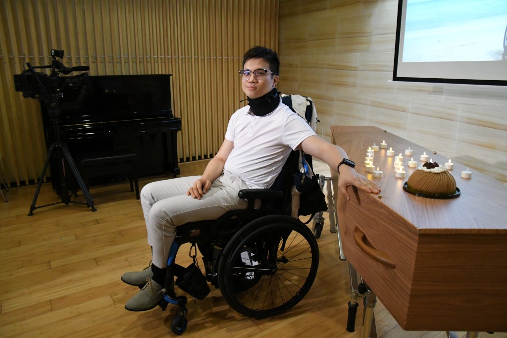  在告別派對尾聲，殯儀社企「一切從簡」創辦人伍桂麟帶領全場來賓進行一場預演送別儀式：來賓先起立閉目，再輪流走近紙棺木，逐一放上白蠟燭致送祝福。隨後，當Hunter再次坐著輪椅進場時，全場報以熱烈掌聲，象徵正式揮別昔日的陰霾，邁向人生新階段。（圖片來源：善寧會）
