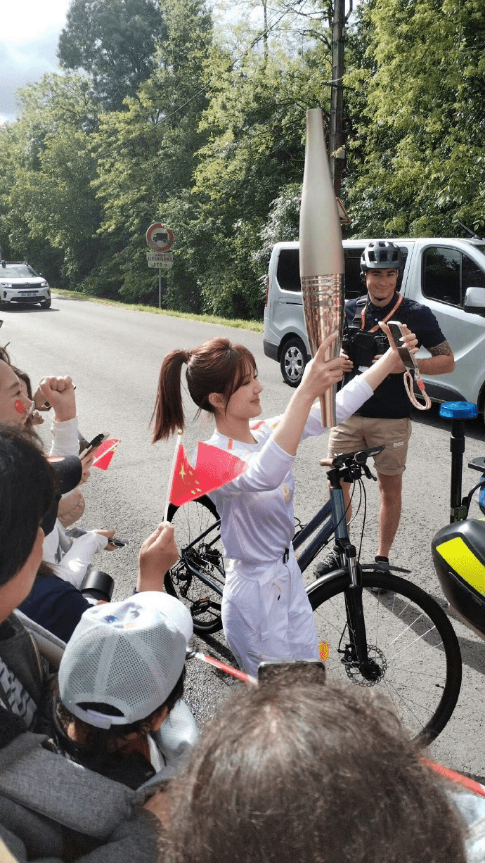 赵露思在奥运圣火传递中，不忘与群众互动自拍。