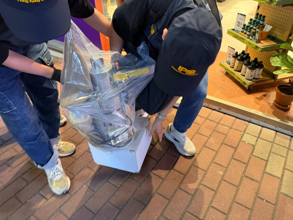 海關在藥店內取走磨粉機。曾志恒攝