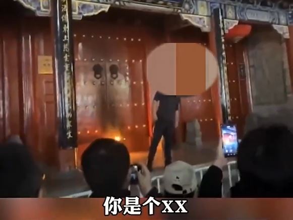 黑衣男在大慈恩寺大門外縱火。影片截圖