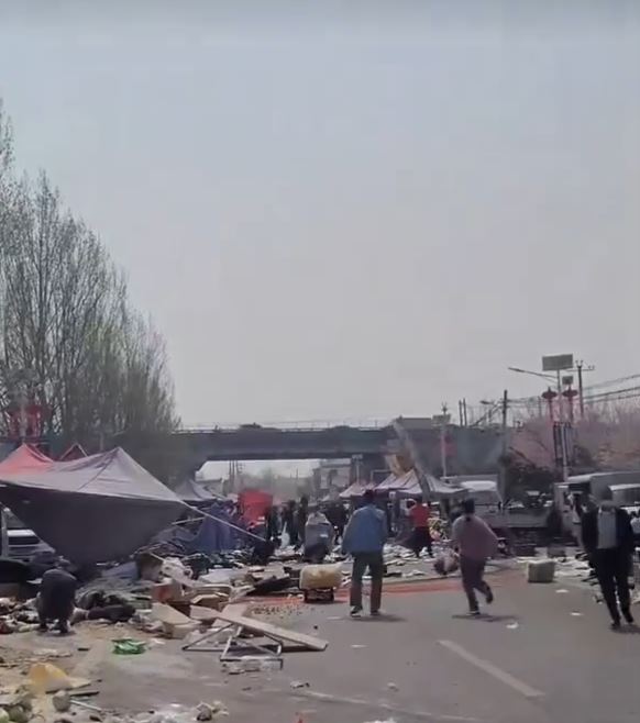 重型铲泥车冲入市集人群，造成多人倒地。Ｘ