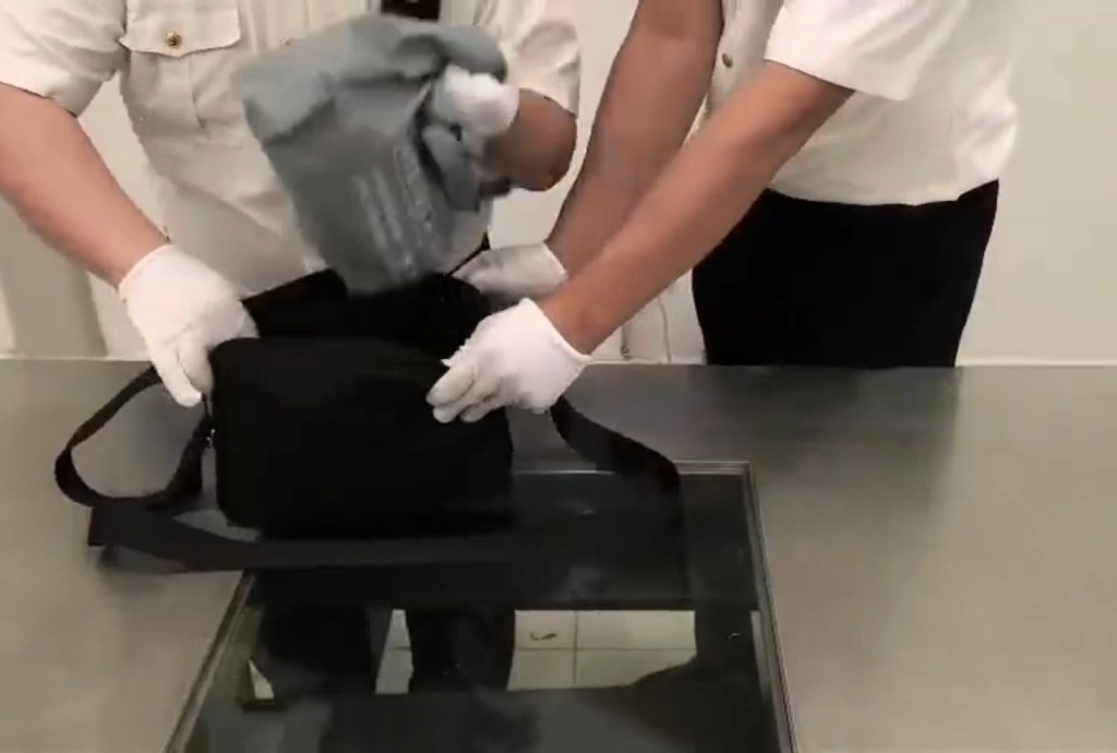 關員在男子斜孭袋內發現116萬港元現金。海關發布 關員在男子斜孭袋內發現116萬港元現金。海關發布
