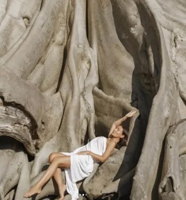 女子用床单包裹裸体，依偎在树上。 IG