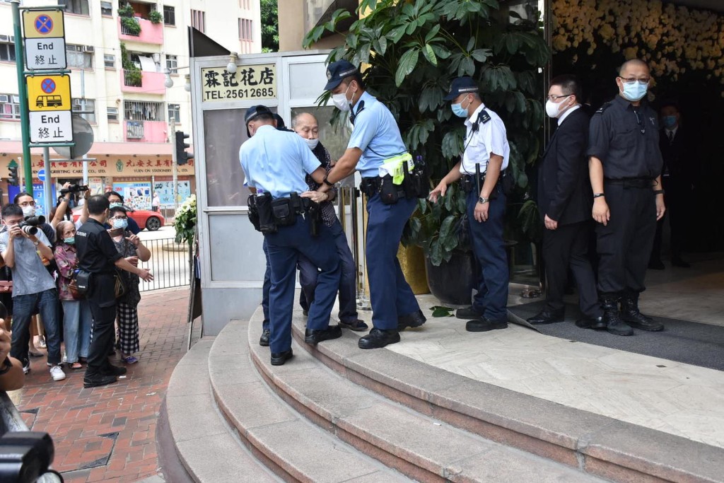 12時許,突然有一位身穿格仔恤衫的伯伯要闖入靈堂,遭警方阻止。