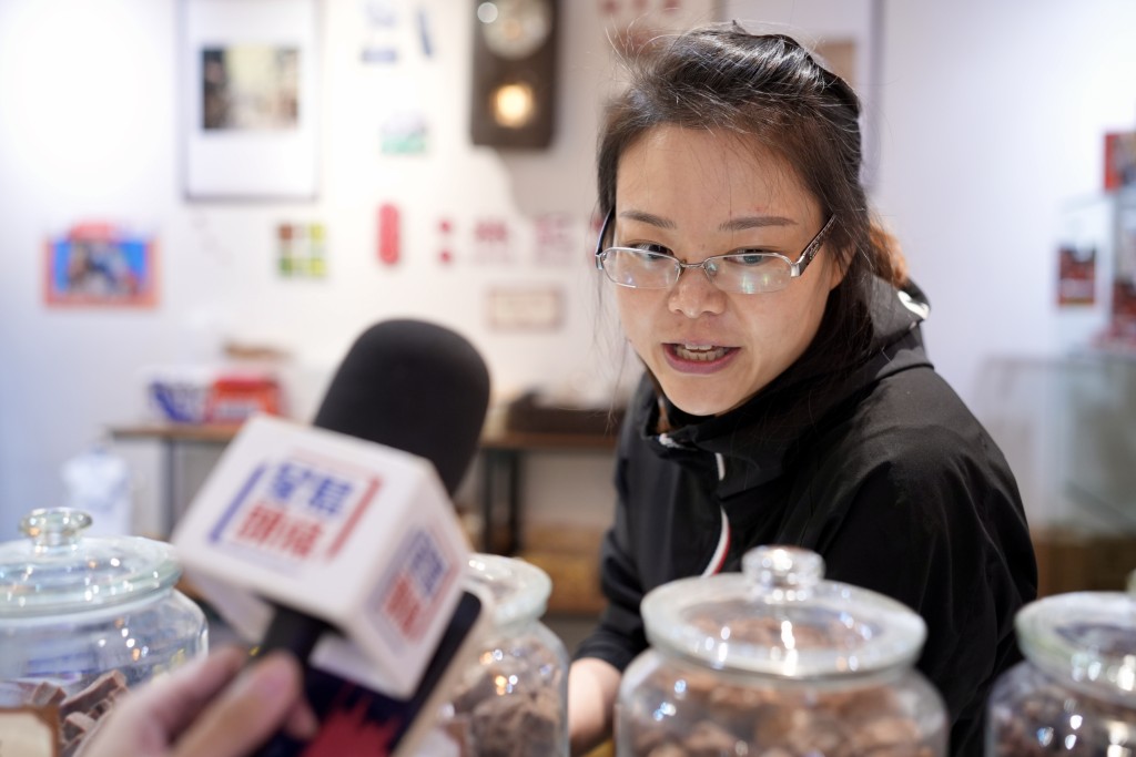 萤幕背后的小食店负责人陈小姐指大萤幕阻挡市民视线，料生意额不会增加。