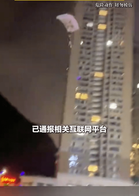 男子深夜貼近樓宇樹叢跳傘。