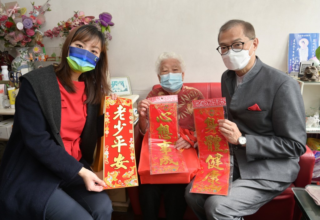 医务衞生局局长卢宠茂教授（右）和署理创新科技及工业局局长张曼莉（左）探访一名独居长者，并送上贺年礼品，表达特区政府的心意。（社交媒体 图片）