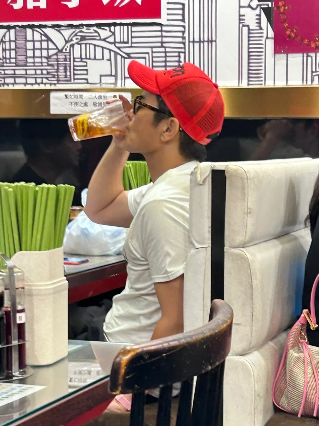 日前有网民分享一张郑嘉颖的照片，见到他头戴红色Cap帽和太阳眼镜，配上白色Tee的休闲打扮，在街坊茶记约了朋友。